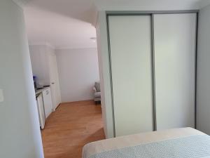 een slaapkamer met een glazen deur naar een keuken bij Sandalwood Guest Room in Margaret River Town