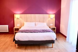 una camera da letto con un grande letto con pareti viola di Aux Lys de Chablis a Chablis