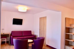 a living room with a red couch and a table and chairs at Aux Lys de Chablis in Chablis