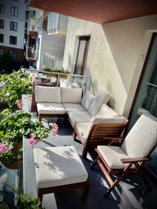 een patio met banken en stoelen op een balkon bij Polanki Paradise in Kołobrzeg