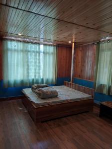 1 dormitorio con 1 cama grande en una habitación de madera en Athithi homestay, en Darjeeling
