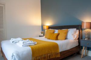 1 dormitorio con 1 cama grande con almohadas amarillas en Bedford Rd Apartment Ideal for Hospital & Town Centre en Kempston
