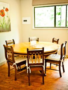 a dining room with a wooden table and chairs at Magoebaskloof Getaway in Magoebaskloof