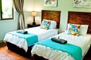 2 camas en una habitación de color azul y blanco en Magoebaskloof Getaway, en Magoebaskloof
