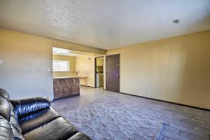 a living room with a leather couch and a kitchen at Pueblo Apt - 10 Mi to Pueblo Mountain Park in Pueblo