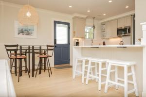 a kitchen with white cabinets and bar stools at Wingspan by Oak Island Accommodations in Oak Island +83 photos