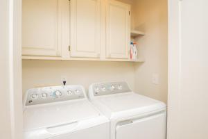 a white laundry room with a washer and dryer at Wingspan by Oak Island Accommodations in Oak Island