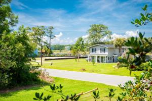 a white house on a lawn with a driveway at Wingspan by Oak Island Accommodations in Oak Island