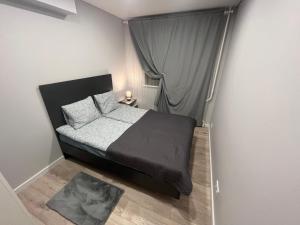 een kleine slaapkamer met een bed en een raam bij City Life in Vilnius