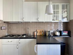 a kitchen with white cabinets and a black counter top at Toast by night in Haarlem