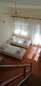 two beds in a room with wooden floors and windows at Villa house Beach house N Hrakleia Xalkidikis No4 in Nea Iraklia
