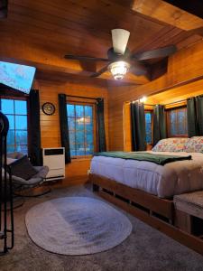 una camera da letto con un letto e un ventilatore a soffitto di The Eagle's Nest Treehouse Cabin a Palmer