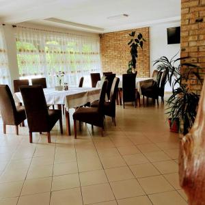 a dining room with a white table and chairs at PASTRAVARIA ALINA in Sîrbi