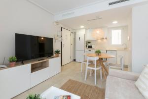 a living room with a couch and a table with a television at Beach & Port in Gandía