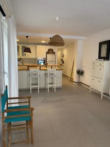 a kitchen with white cabinets and a table and chairs at Casa Portoblau in Porto Cristo