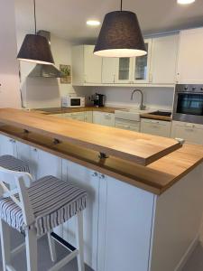 cocina con armarios blancos y encimera de madera en Casa Portoblau en Porto Cristo