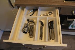 a drawer filled with utensils in a cabinet at Ferienwohnung Landsberg am Lech in Landsberg am Lech