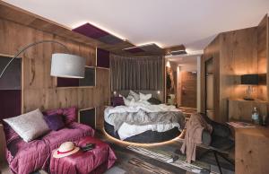 ein Schlafzimmer mit einem Bett und einem Sofa in der Unterkunft Terentnerhof 4*S active & lifestyle hotel in Terenten