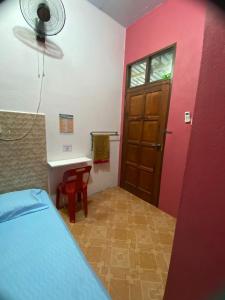 een slaapkamer met een bed en een rode muur bij Rumah Hentian Ayah in Kampung Kuala Besut