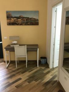 a desk in a room with a chair and a painting at Ballarò Holiday in Palermo