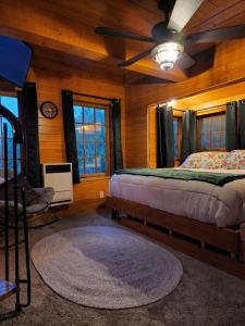 Schlafzimmer mit einem Bett und einem Deckenventilator in der Unterkunft The Eagle's Nest Treehouse Cabin in Palmer