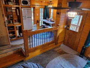 una camera con pareti in legno e una cucina con frigorifero di The Eagle's Nest Treehouse Cabin a Palmer