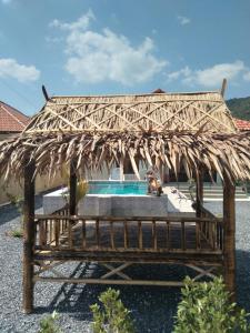 Ban Ai Dao的住宿－Villa MILTONIA，游泳池旁长凳上的一把草伞