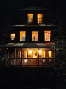 ein großes Haus mit nachts eingeschaltetem Licht in der Unterkunft The Eagle's Nest Treehouse Cabin in Palmer
