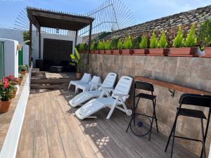 un groupe de chaises blanches assises sur une terrasse dans l'établissement Apartamentos Jerez, à Jerez de la Frontera