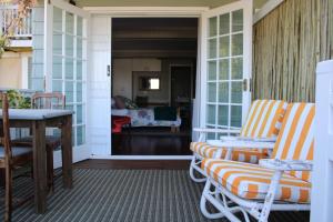 a porch with two chairs and a table at 14 Mount Joy in Knysna