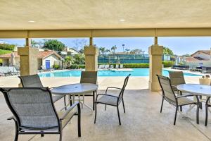 a patio with tables and chairs and a pool at Bright Townhome in Carlsbad 1 Mile to Beach! in Carlsbad