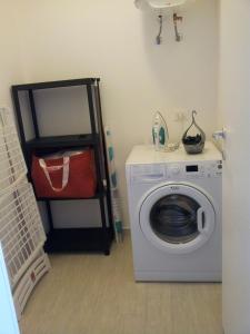 a laundry room with a washing machine and a shelf at Essenzamare in San Vito lo Capo