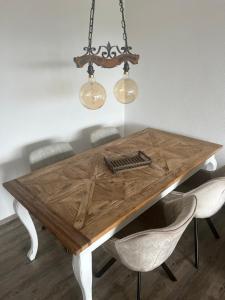 un tavolo da pranzo in legno con sedie e un lampadario di Apartment Annis Panoramablick Pool Sauna Tennis a Obertal