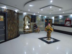テナにあるHotel Joya de la Selvaの花瓶に花を置いた部屋の中に座っている女性 +70枚の写真