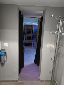 Baño con ducha a ras de suelo junto a una puerta en Virtuel Spa en Achicourt