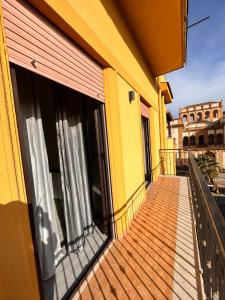 un balcone di un edificio giallo con finestre di Casa vacanza CUTÓ a Bagheria