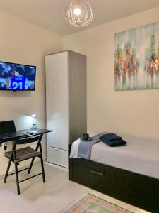 a bedroom with a bed and a desk with a laptop at Small Private Studio in heart of Valencia - Rusafa in Valencia