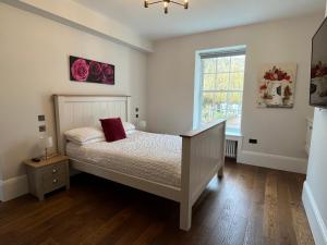a bedroom with a bed and a window at Stunning and luxurious Manor House holiday home in Broadmayne