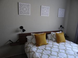 - une chambre avec un lit et des oreillers jaunes dans l'établissement B&B Casa Sarandy, à Almogía