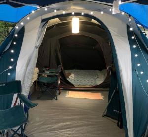 a tent with a bed and a table in it at Pousada camping Recanto Joanópolis in Joanópolis