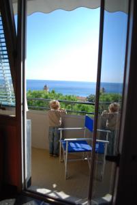 twee kinderen op een balkon met uitzicht op de oceaan bij Hotel Palace in Varazze