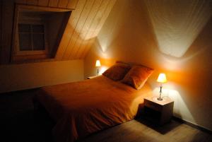 a bedroom with a bed with two lamps on it at Gîte Binnert Bader in Nothalten