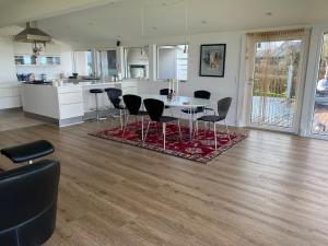 uma cozinha e sala de estar com mesa e cadeiras em Strandhuset. em Asperup