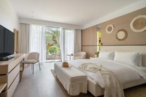 a bedroom with a large white bed and a desk at METT Hotel & Beach Resort Bodrum in Bodrum City