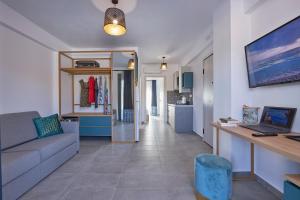 uma sala de estar com um sofá e uma cozinha em GreyStoneApartments em Paralia Dionysiou