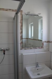 ein Bad mit einem Waschbecken und einem Spiegel in der Unterkunft Ferienwohnung Landsberg am Lech in Landsberg am Lech