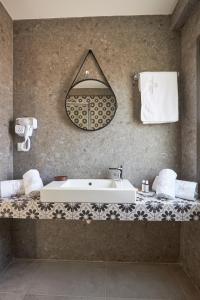uma casa de banho com um lavatório branco e um espelho. em GreyStoneApartments em Paralia Dionysiou