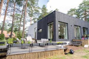 a black modular home with a deck and furniture at Loft 3 rooms riverside by Gauja.Club - Residences in Gauja