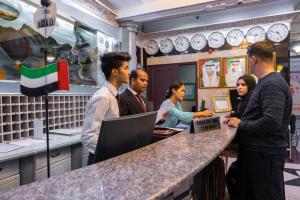 a group of people standing around a counter in an office at Three 888 Hotel in Dubai
