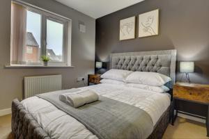 a bedroom with a large bed and two windows at Tudor Close in Sheffield